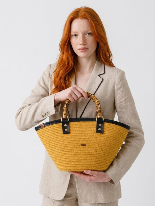 Bolso Ámbar  artesanal de cuerda de algodón con asas de bambú llevado por na mujer
