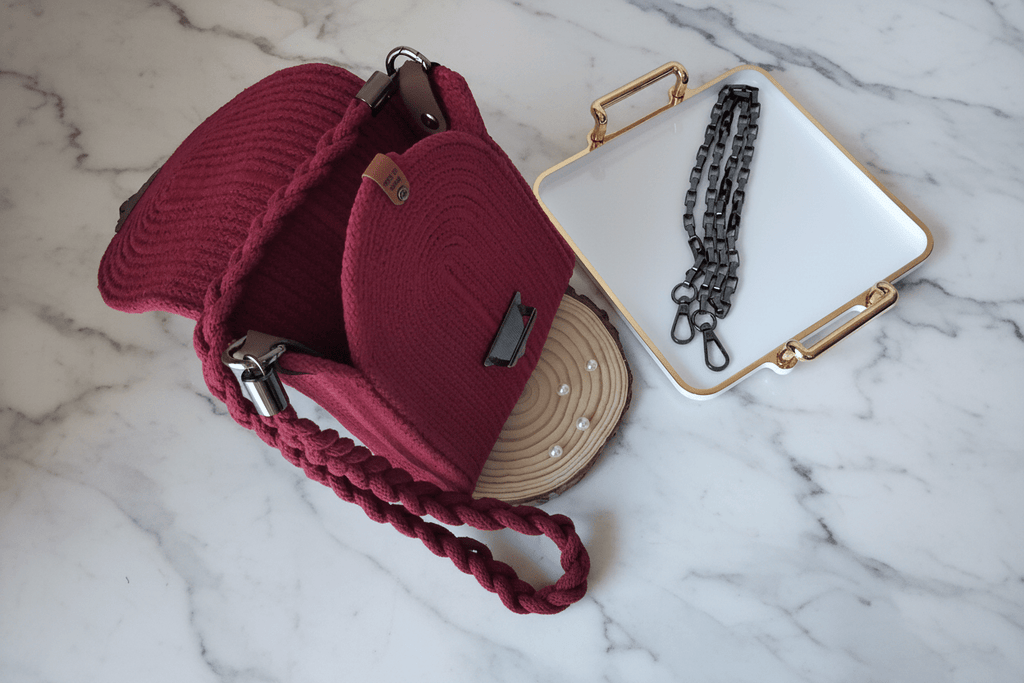 Mini Bolso Rubí artesanal abierto ensenando el interior, correa trenzada y cadena metálica.